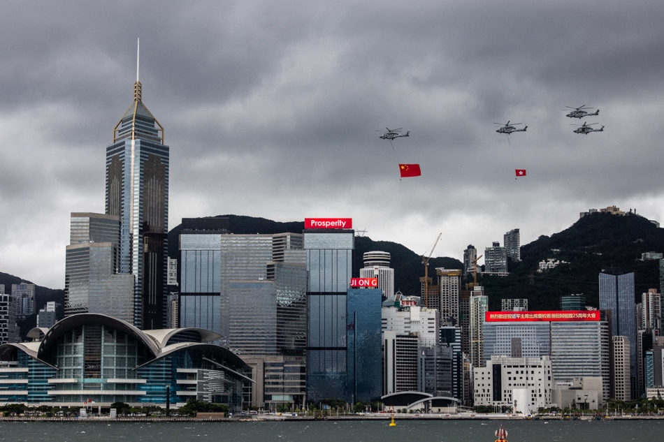 Helicopters fly past with the Hong Kong and Chinese flags during a flag-raising ceremony to celebrate the 25th anniversary of the city's handover from Britain to China, in Hong Kong on July 1, 2022. Isaac Lawrence, AFP