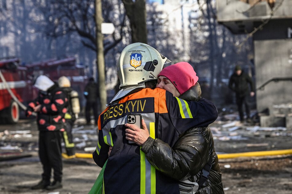 A fireman embraces a woman outside a damaged apartment building in Kyiv on March 15, 2022, after strikes on residential areas killed at least 2 people. Aris Messinis, AFP/File 
