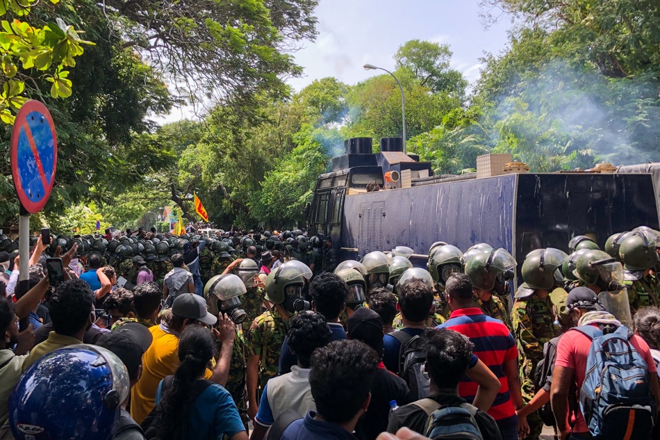 Demonstrators take part in an anti-government protest outside the office of Sri Lanka's prime minister in Colombo on July 13, 2022. Sri Lankan police fire tear gas to hold back thousands of demonstrators mobbing the premier's office in Colombo on July 13, AFP reporters at the scene saw. AFP 