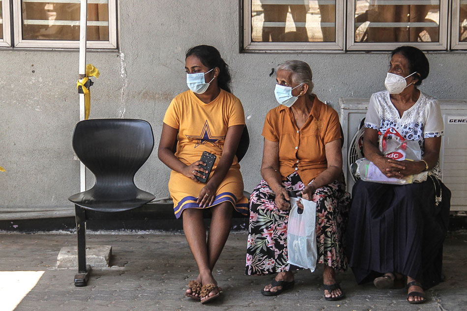 In this picture taken on July 19, 2022, patients wait for their appointment with medical staff outside a ward at the National Hospital in Colombo. Entire wards are dark and nearly empty in Sri Lanka's largest hospital, its few remaining patients leaving untreated and still in pain, and doctors prevented from even arriving for their shifts. An unprecedented economic crisis has dealt a body blow to a free and universal healthcare system that just months earlier was the envy of the country's South Asian neighbours. AFP