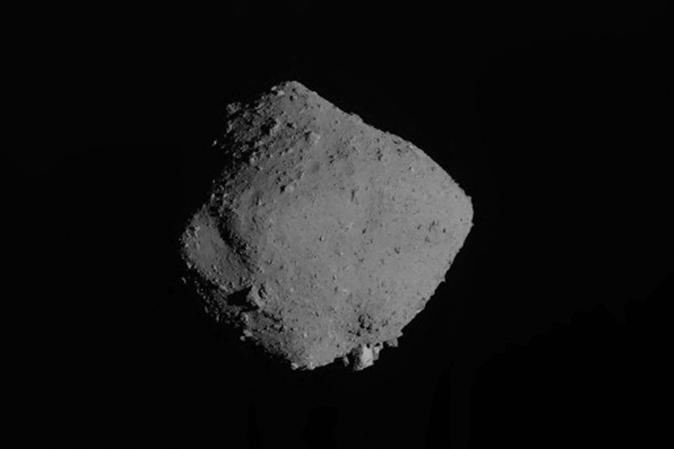 This file handout photograph released by Japan Aerospace Exploration Agency (JAXA) via Jiji Press on November 13, 2019 shows the asteroid Ryugu after Hayabusa2 departed its orbit around a distant asteroid and head for Earth. Specks of dust retrieved by a space probe from the asteroid Ryugu some 300 million kilometers from Earth have revealed a surprising component: a drop of water, scientists said on September 23, 2022. Handout / JAXA via Jiji Press / AFP