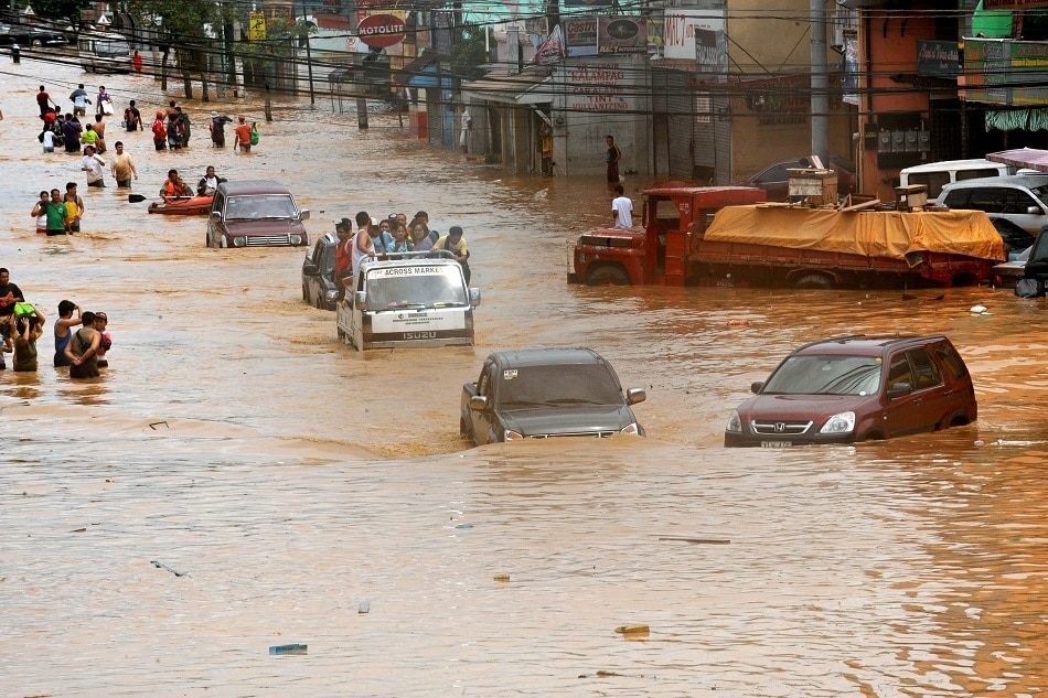 File photo taken on September 27, 2009 shows motorists crossing a flooded road in Marikina, east of Manila on September 27, 2009, a day after tropical storm Ketsana lashed the area around the capital city. Ted Aljibe, AFP/file