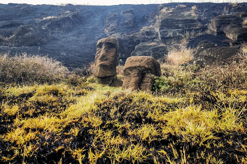 This handout picture released by the Rapanui Municipality shows Moais -- stone statues of the Rapa Nui culture -- affected by a fire at the Rapa Nui National Park in Easter Island, Chile, on October 6, 2022. Rapanui Municipality / AFP 