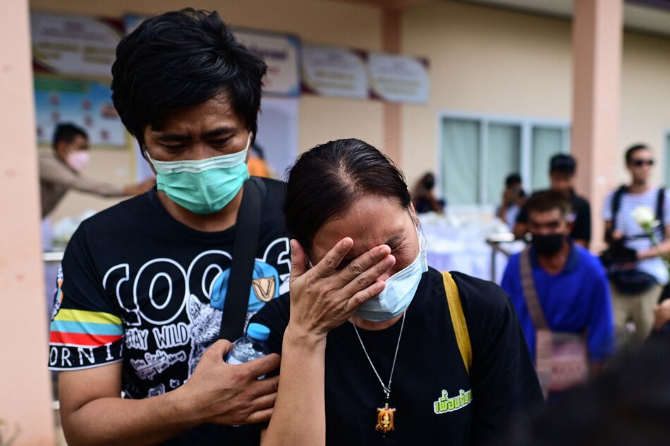 A woman cries after laying white roses on the steps of the nursery, where a former police officer killed at least 37 people in a mass shooting, in Na Klang in Thailand's northeastern Nong Bua Lam Phu province on October 7, 2022. Weeping, grief-stricken families gathered on October 7 outside a Thai nursery where an ex-policeman murdered nearly two dozen young children in one of Thailand's worst mass killings. Manan Vatsyayana, AFP 
