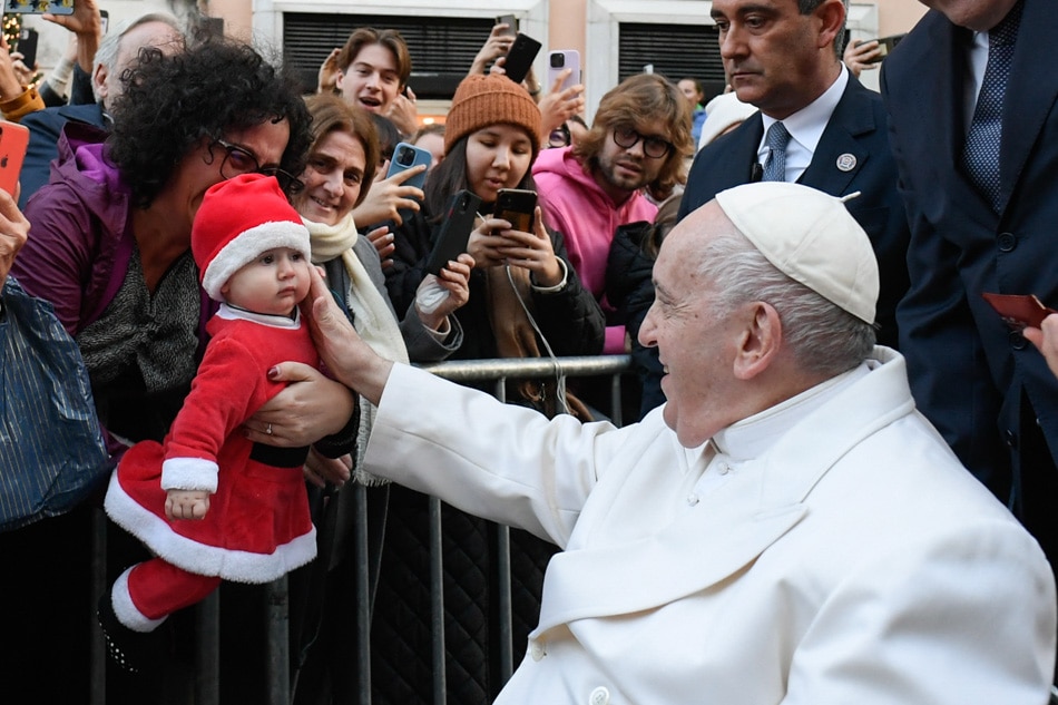 Pope Francis blesses a toddler as he pays a traditional visit on Dec. 8, 2022 to the statue dedicated to the Immaculate Conception near Piazza di Spagna in central Rome, celebrating the Solemnity of the Immaculate Conception. The Immaculate Conception is the church doctrine that the Virgin Mary, mother of Jesus, was exempted of the original sin from the moment of her conception. Vatican Media handout, AFP