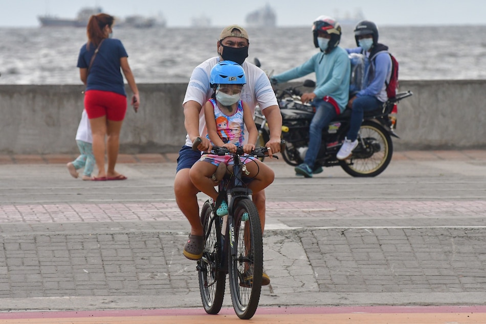 Families stroll along the Manila Baywalk as the country maintains pandemic restrictions. Mark Demayo, ABS-CBN News file