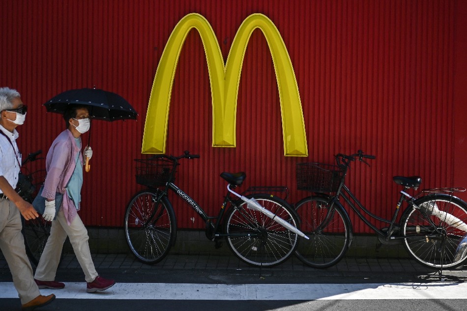People walk past a McDonald's logo in Tokyo on July 19, 2020. Charly Triballeau, AFP
