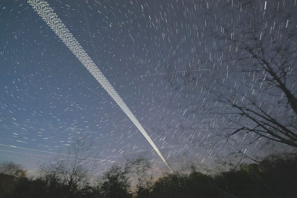 A digital stacked combination of multiple exposures shows a train of brightly-lit SpaceX Starlink 24 mission satellites pass the night sky in train formation near Herrnleis, Austria, 09 May 2021. Christian Bruna/EPA