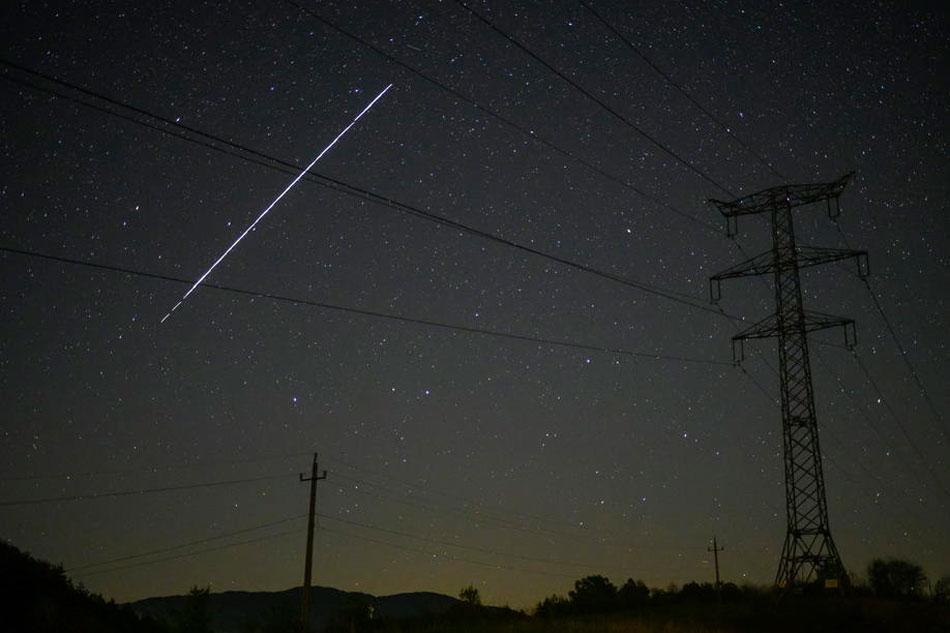 A photo taken using a long exposure shows a string of SpaceX StarLink satellites passing over Salgotarjan, Hungary, May 12, 2021. The trail of lights was the result of a series of relatively low-flying satellites launched by Elon Musk's SpaceX as part of its Starlink internet service earlier this month. Peter Komka, EPA-EFE/File 