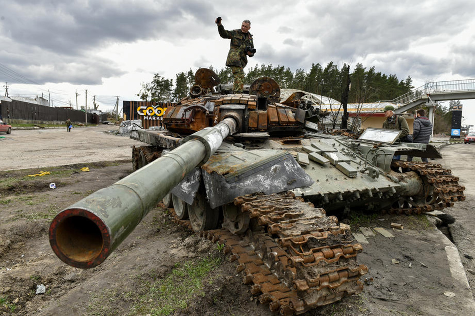 A man stands on destroyed russian tanks in Buzova village of Kyiv (Kiev) area, Ukraine, 11 April 2022. Oleg Petrasyuk, EPA-EFE