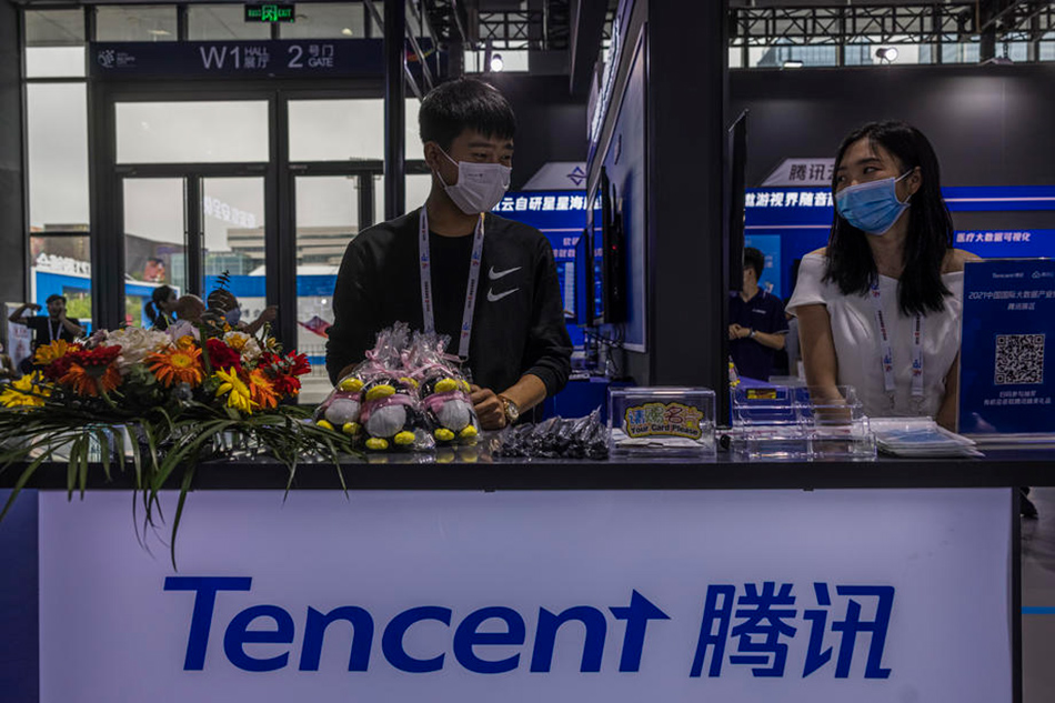 Hostesses stand on a Tancent company booth on the Big Data Expo in Guiyang, Guizhou province, China, May 26, 2021. Alex Plavevski, EPA-EFE/File
