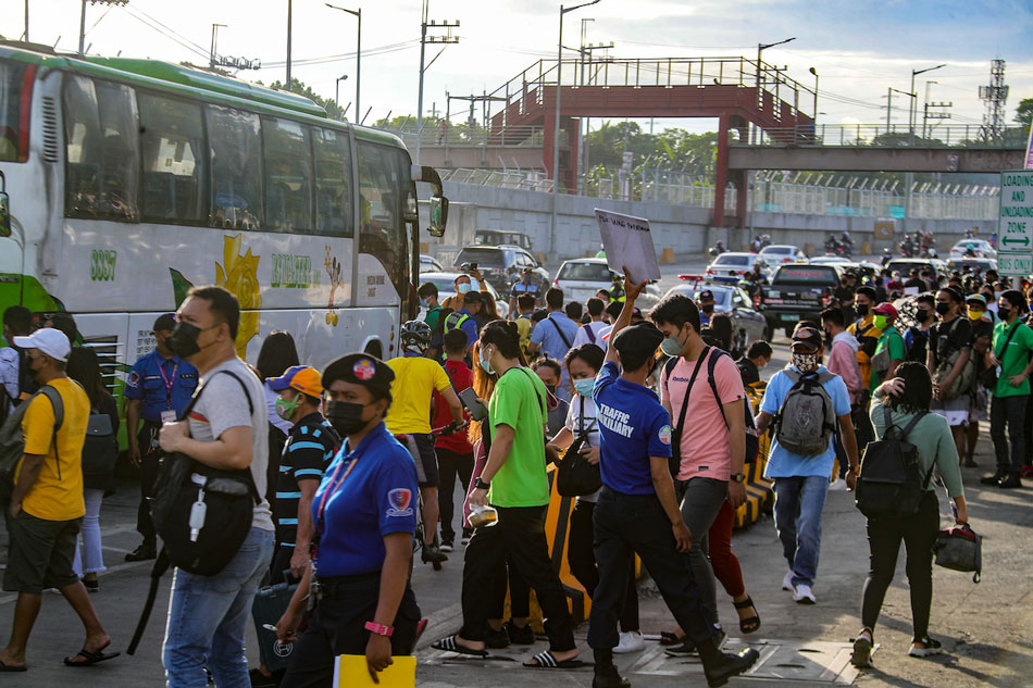  Members of the Metro Manila Development Authority (MMDA) assist commuters taking public transportation on Commonwealth-Litex Road in Quezon City on April 8, 2022. Jonathan Cellona, ABS-CBN News 
