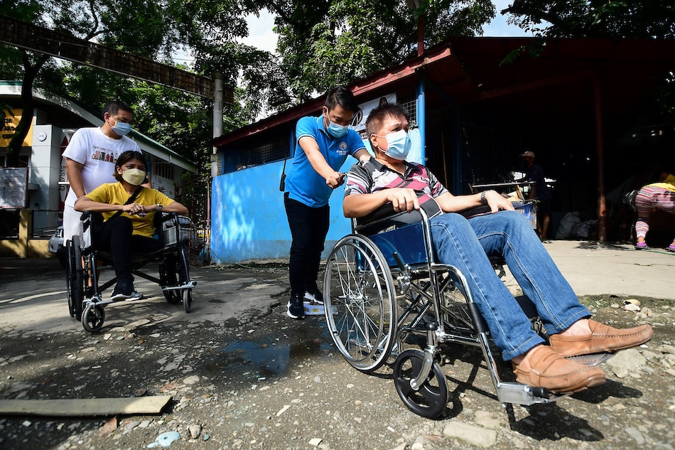 Participants navigate an unpaved road as advocates for inclusive mobility conduct an accessibility walkthrough with local officials and community organizers in Brgy. Milagrosa in Quezon City on July 24, 2022, in line with the observance of the 44th National Disability Prevention and Rehabilitation Week. Mark Demayo, ABS-CBN News 