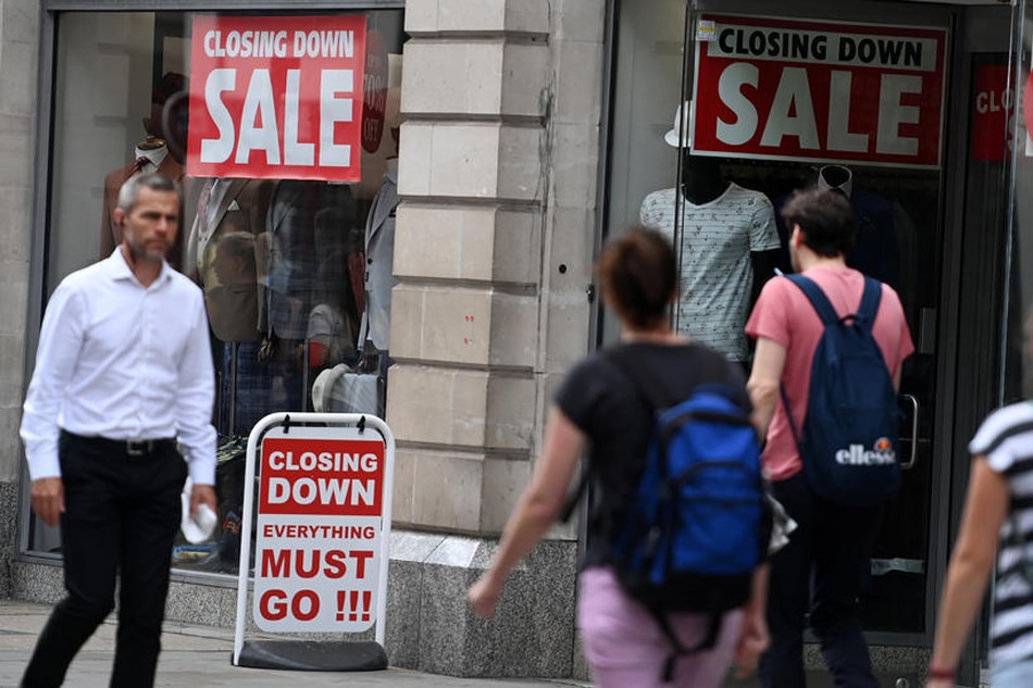 Pedestrians pass a closing down sale at a store in central London, Britain, on August 4, 2022. Andy Rain, EPA-EFE/file