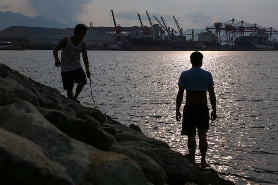 Residents take a stroll along the banks of the Subic Bay Freeport Zone with a view of container ships docked on the horizon on Tipo, Subic, North of Manila on May 30, 2019. Jonathan Cellona, ABS-CBN News