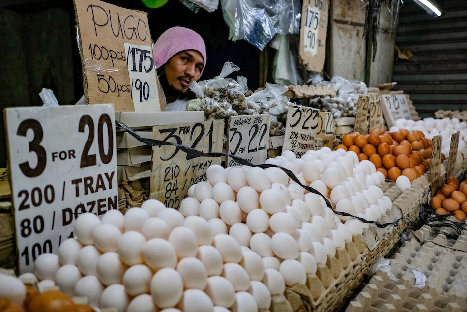 A vendor looks through his egg products for sale at a public market in Quezon City on July 19, 2022. George Calvelo, ABS-CBN News