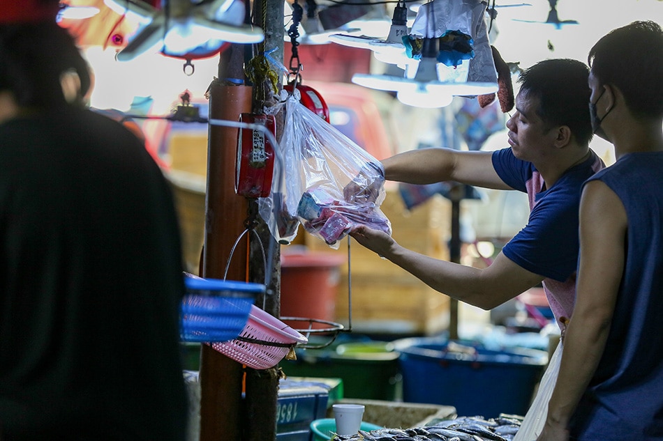 Fish vendors attend to their customers at the fish section of the Commonwealth Market in Quezon City on Nov. 24, 2022. Jonathan Cellona, ABS-CBN News