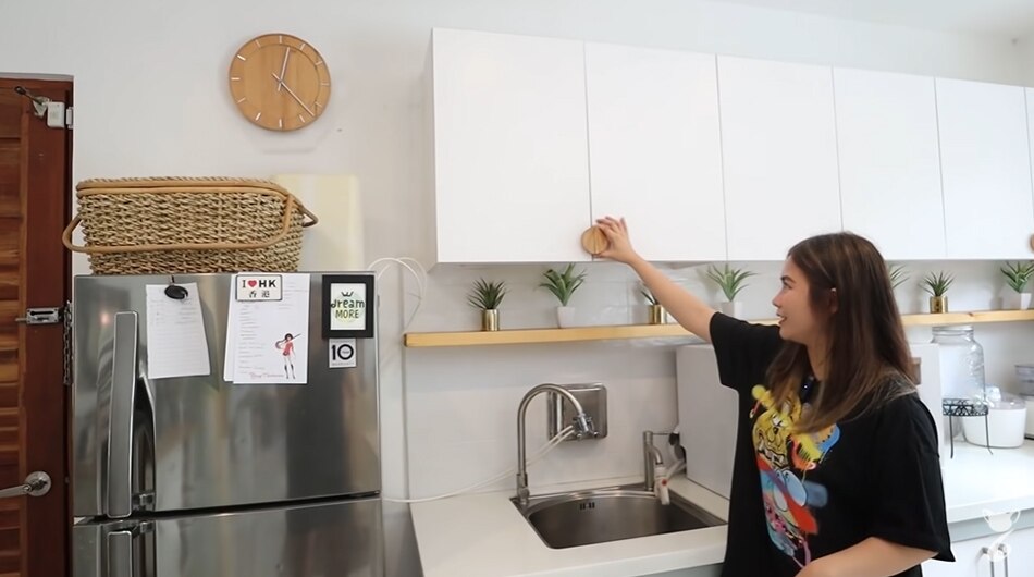 The cabinet handles match the wall clock in terms of material and shape. Screengrab from Yeng Constantino's YouTube page