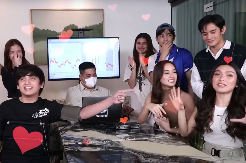 Seth Fedelin (left, front) takes the lie detector test in front of his on-screen partner Francine Diaz (right, front) and the rest of The Squad. Screengrab from The Squad's YouTube channel