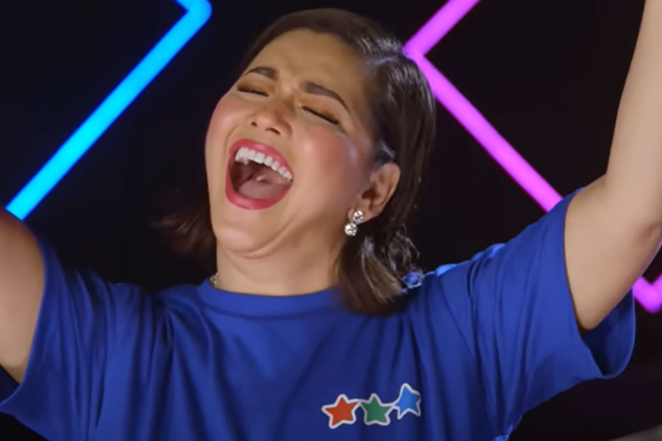Still from CID 2022 Regine V raising her hands during bridge - 10:49 TC in main CID - U] Caption: Regine Velasquez delivers the high note at the end of the bridge of the 2022 ABS-CBN Christmas ID “Tayo Ang Ligaya Ng Isa’t Isa”. Photo courtesy: ABS-CBN