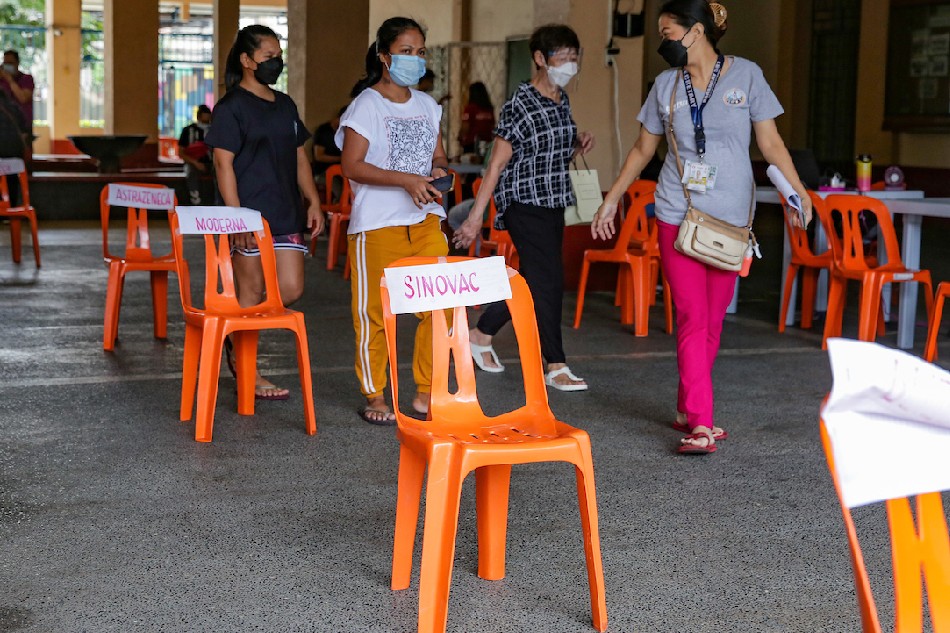 People exit the site after getting vaccinated at the Ramon Magsaysay Highschool in Manila on Dec. 30, 2021. George Calvelo, ABS-CBN News