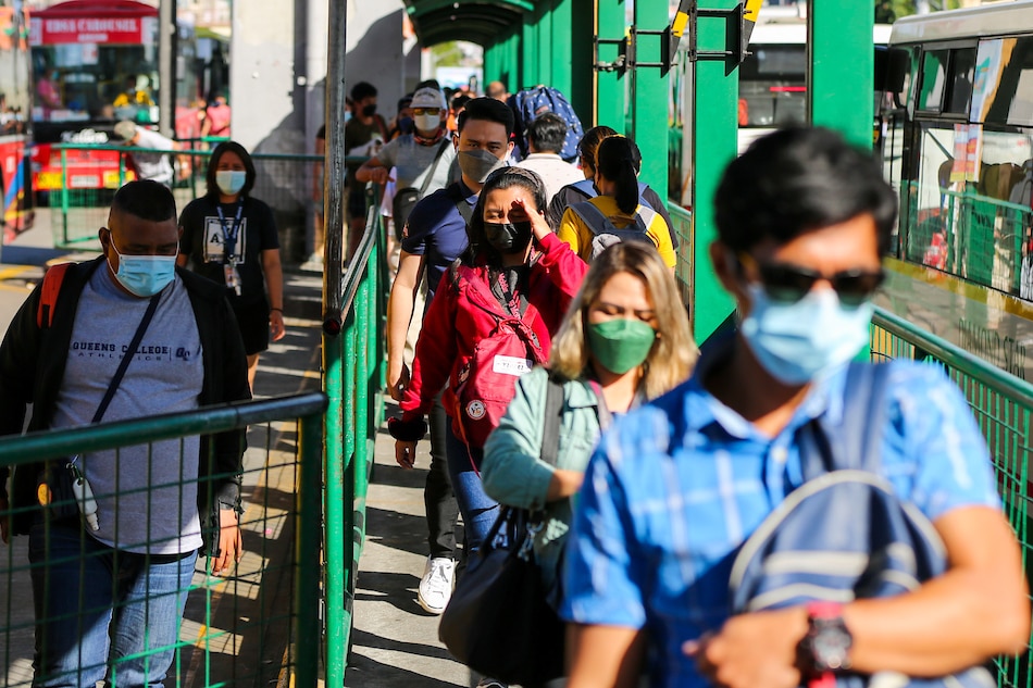 People wearing face masks as a precaution against COVID-19 fall in line at the Monumento bus stop in Caloocan on January 3, 2021. Jonathan Cellona, ABS-CBN New
