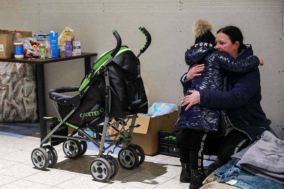 A woman hugs her child at the new refugee center that opened in the CH-Tesco facility in the town of Przemysl, Poland, March 2, 2022. Miguel A. Lopes, EPA-EFE