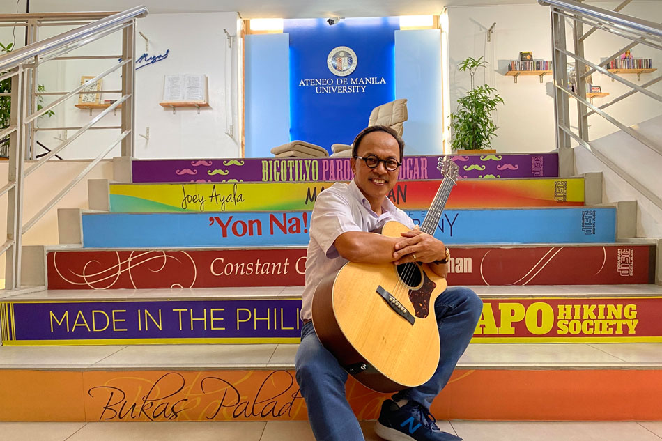 Singer-songwriter Noel Cabangon sitting on the steps of Ateneo