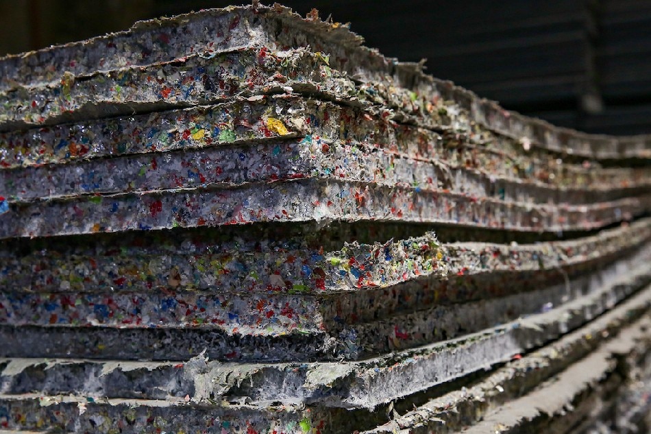 Stacked eco-boards are stored inside The Plastic Flamingo upcycling factory in Muntinlupa City on March 18, 2022. George Calvelo, ABS-CBN News