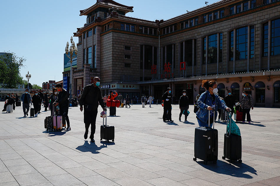 People wait outside the Beijing Railway Station EPA-EFE