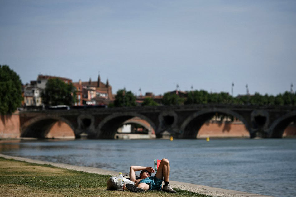A man reads on the Garonne river bank AFP/file