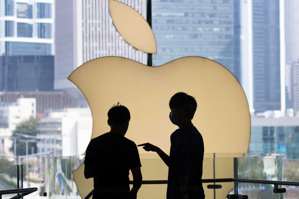 Staff talk in front of the Apple Inc. logo at the company’s store in Central, Hong Kong, China, March 15, 2022. Jerome Favre, EPA-EFE/File 