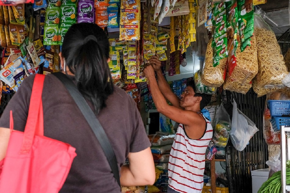 Vendors and customers gather at a sari-sari store in Quezon City on May 27, 2022. George Calvelo, ABS-CBN News