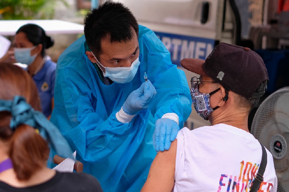 A health worker administers COVID-19 vaccine shot to a resident of Bangkal, Makati on Aug. 18, 2022. George Calvelo, ABS-CBN News