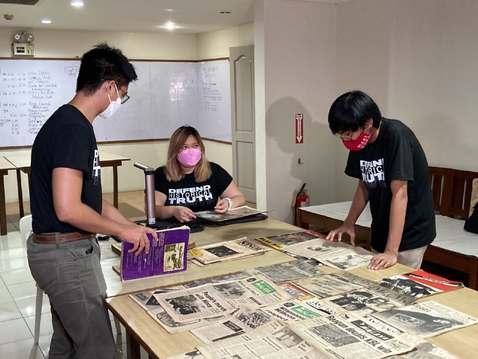Members of Project Gunita look at a pile of newspapers for archiving. Mike Navallo, ABS-CBN News