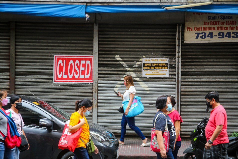 People pass by closed shops, some of which were affected by the ongoing COVID-19 pandemic, in Binondo, Manila during Chinese New Year on February 1, 2022. Jonathan Cellona, ABS-CBN News/FILE