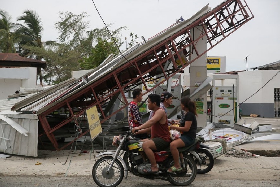 Motorists drive past a damaged gas station in Cabiao, Nueva Ecija on September 26, 2022, the day after Typhoon Karding hit the region. Jonathan Cellona, ABS-CBN News
