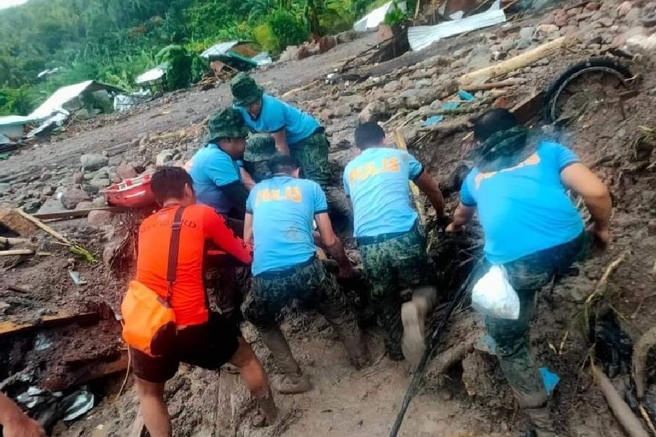 A handout photo made available by Philippine Coast Guard shows policemen and a coastguard personnel pulling a body they retrieved during a rescue operation in Brgy. Kushong, Datu Odin Sinsuat town, Maguindanao, October 28, 2022. PCG handout, EPA-EFE