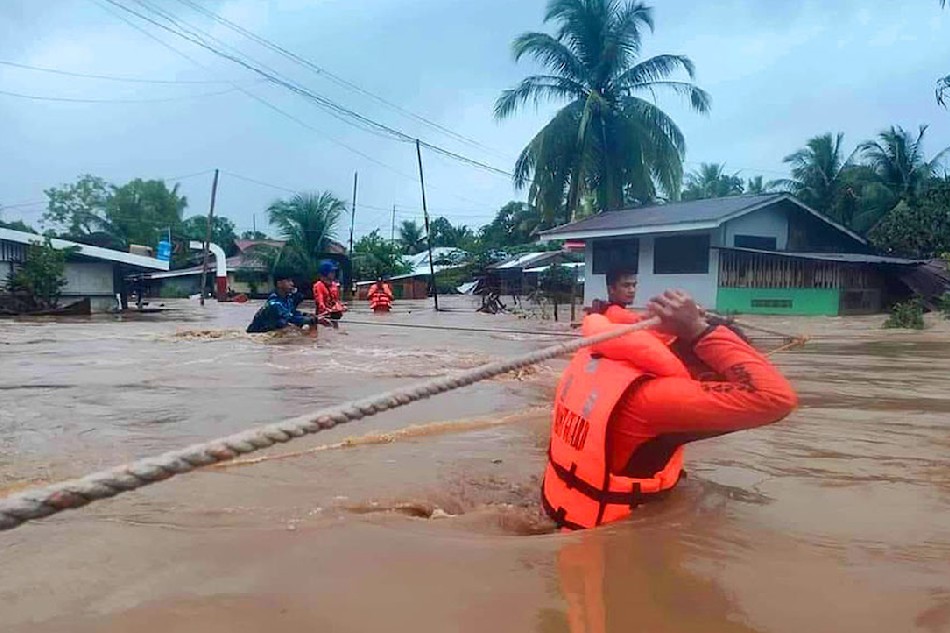Philippine Coast Guard (PCG) personnel wade in deep floodwaters on Friday to rescue trapped in parts of the Bangsamoro Autonomous Region in Muslim Mindanao. Handout Photo