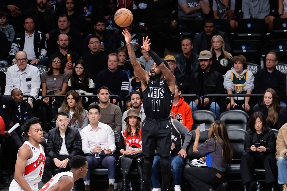 Brooklyn Nets guard Kyrie Irving (C) shoots over Toronto Raptors defenders during the first half of the NBA basketball game between the Brooklyn Nets and the Toronto Raptors at Barclays Center, in Brooklyn, New York, USA, 21 October 2022. Peter Foley, EPA-EFE.