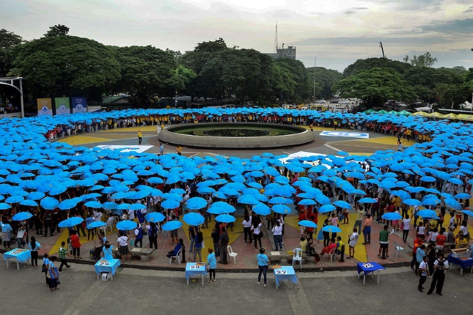 Thousands gather at the Quezon City Memorial Circle for a synchronized opening of umbrellas to form a blue circle in celebration of World Diabetes Day on Thursday. The event is attempting to enter the Guinness Book of World Records for the feat. Manny Palmero, ABS-CBN News
