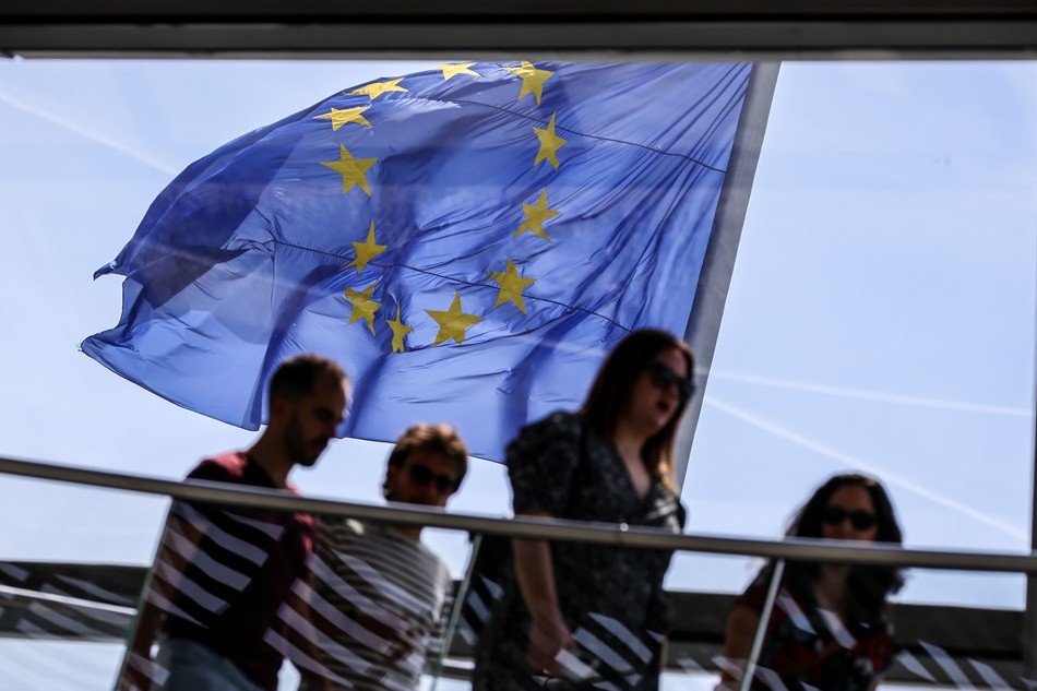 The European Union (EU) flag flies in the wind as visitors pass by at the observatory dome of the Reichstag in Berlin, Germany, May 19, 2022. Omer Messinger, EPA-EFE
