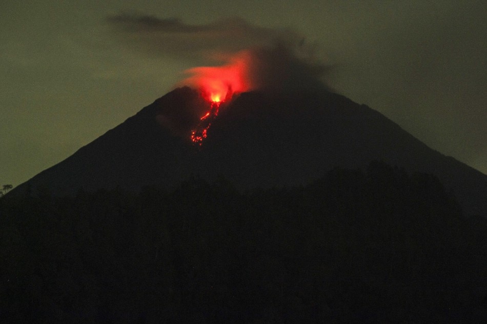 A photo taken using a slow shutter speed shows Mount Semeru spewing hot lava as seen from Lumajang, East Java, Indonesia, 06 December 2021. EPA-EFE/AMMAR/file