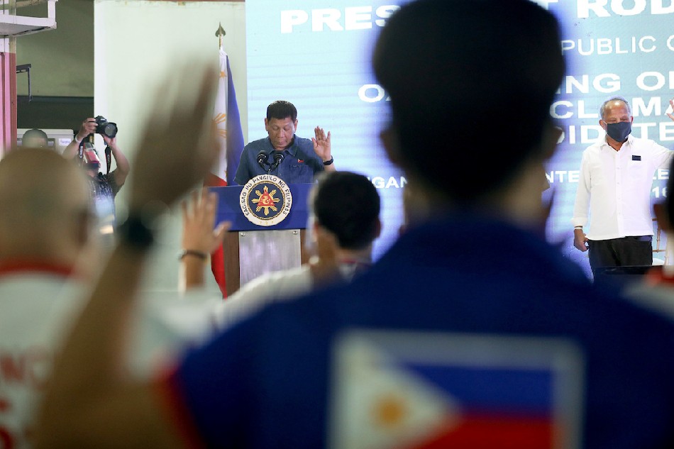 President Rodrigo Duterte, chairman of the Partido Demokratiko Pilipino - Lakas ng Bayan (PDP- Laban), administers the oath to new members of the party during the ceremony and proclamation of local candidates at the Iligan Medical Center College Auditorium in Iligan City on Oct. 16, 2021. Ace Morandante, Presidential Photo/File
