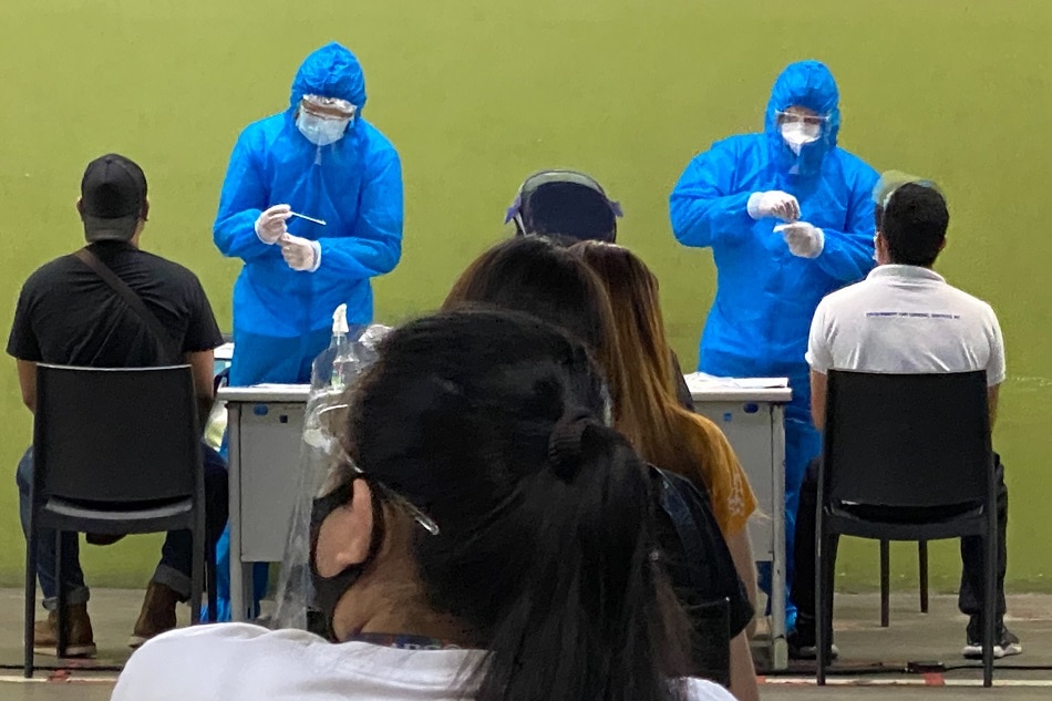 Healthcare workers dressed up in full PPE suits administer RT-PCR tests for COVID-19 at a private company in Quezon City on April 10, 2021. Fernando G. Sepe Jr., ABS-CBN News/file