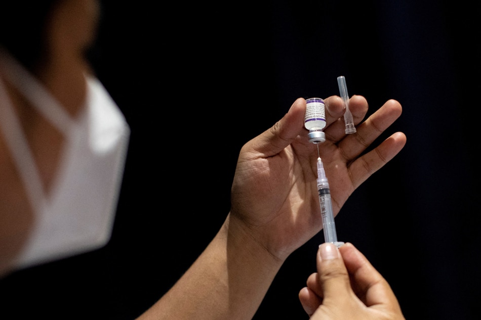 A health worker prepares a dose of COVID-19 vaccine at a cinema turned into a temporary vaccination site in San Juan, on December 15, 2021. Eloisa Lopez, Reuters