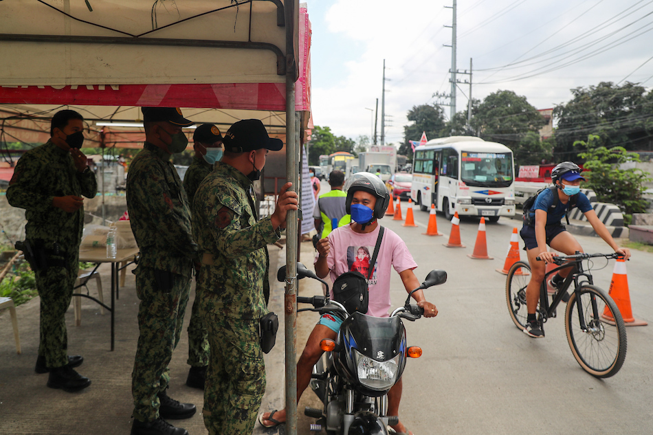 Policemen check the vaccination cards of travelers passing through the San Jose Del Monte and Quezon City border on Jan. 6, 2022. Jonathan Cellona, ABS-CBN News