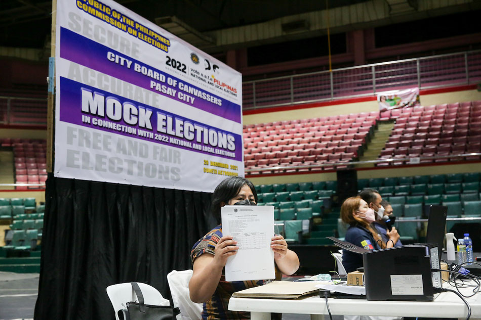 A member of the city board of canvassers shows the printout of the canvass report for COMELEC’s mock elections held inside the Cuneta Astrodome in Pasay City on Dec. 29, 2021. George Calvelo, ABS-CBN News