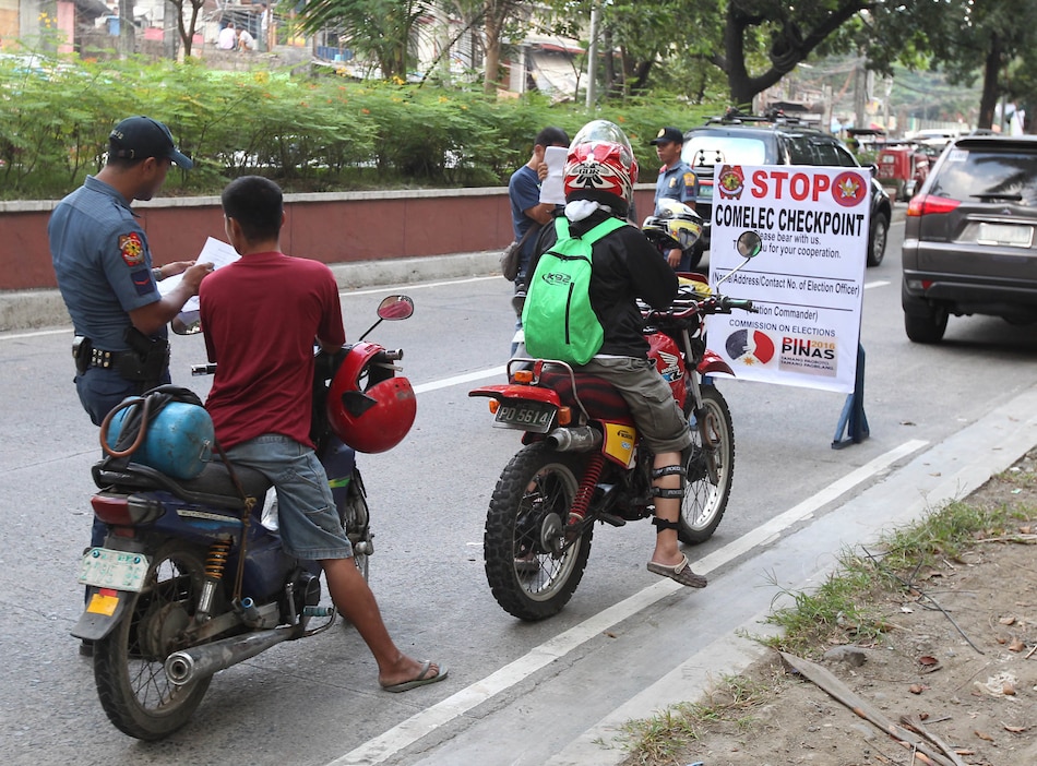 Members of the Quezon City Police District man a COMELEC checkpoint along Agham Road in Quezon City on Monday. COMELEC checkpoints were set up nationwide as the national election period begins Sunday, with a gun ban being implemented until June 8. Manny Palmero, ABS-CBN News