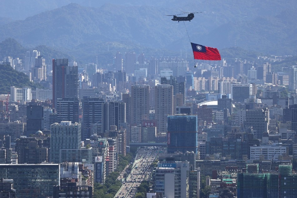 A Taiwan flag is carried by a Chinook helicopter during a rehearsal for the upcoming National Day celebration in Taipei, Taiwan October 7, 2021. REUTERS/Ann Wang/File Photo